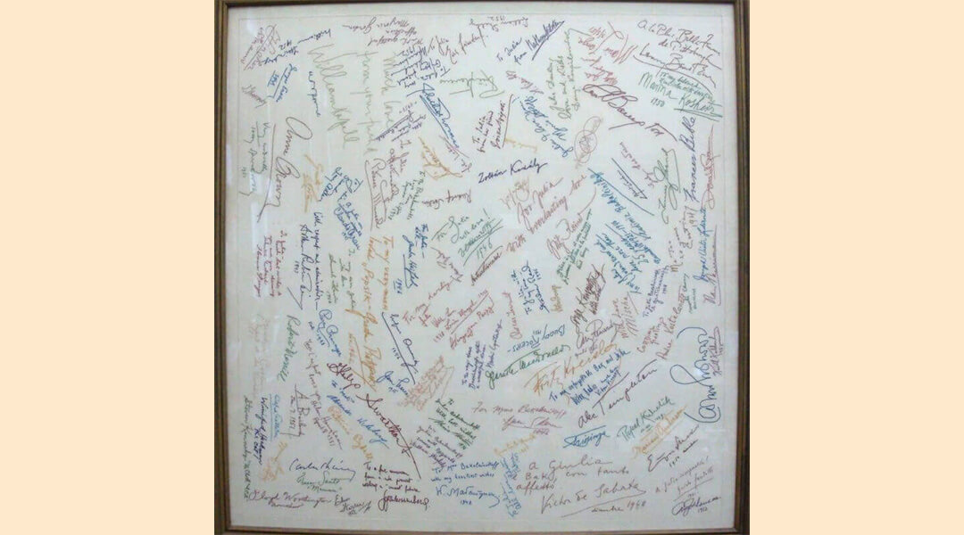 White tablecloth mounted in a frame with autographs of famous musical visitors to Pittsburgh in the 1940's and 1950's. Each autograph is embroidered over in colorful thread.