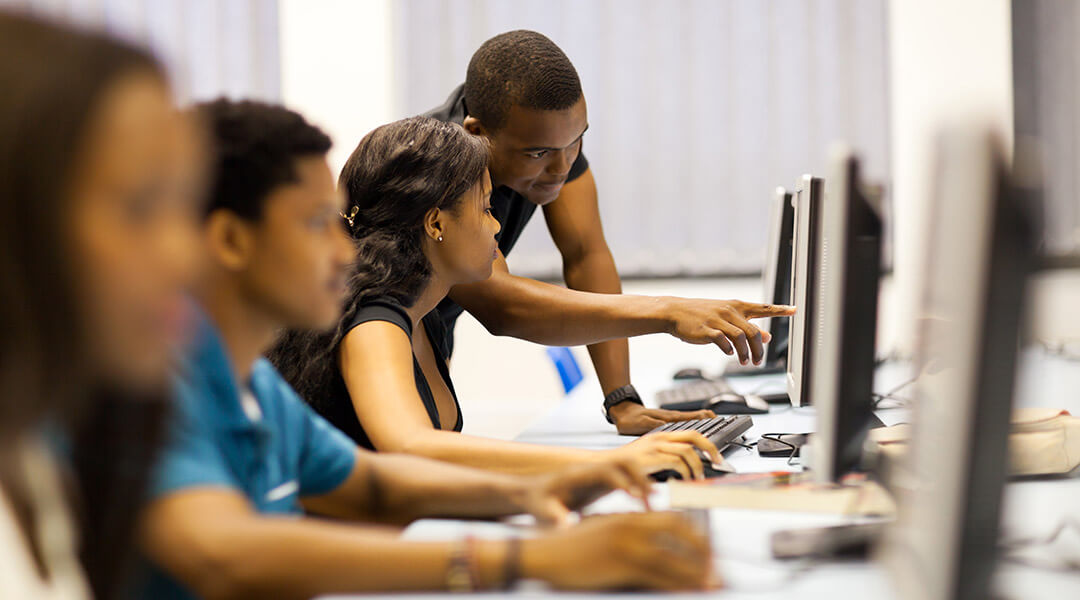 A librarian points to information on a computer screen.