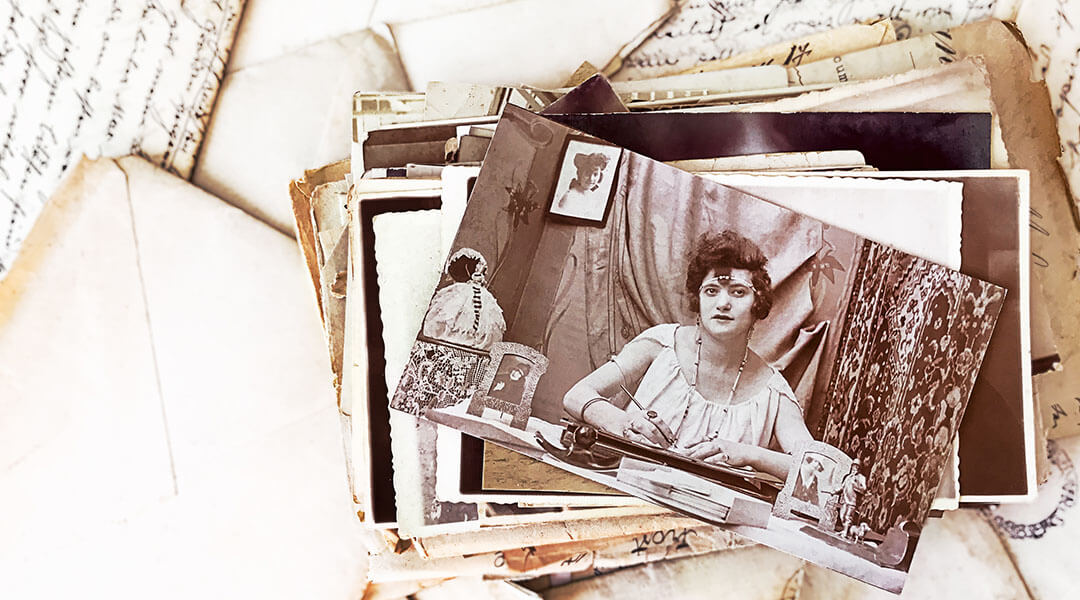 Pile of vintage photographs on top of old letters.