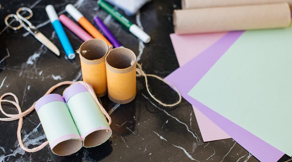 Toilet paper rolls repurposed as crafts with colored paper and twine.