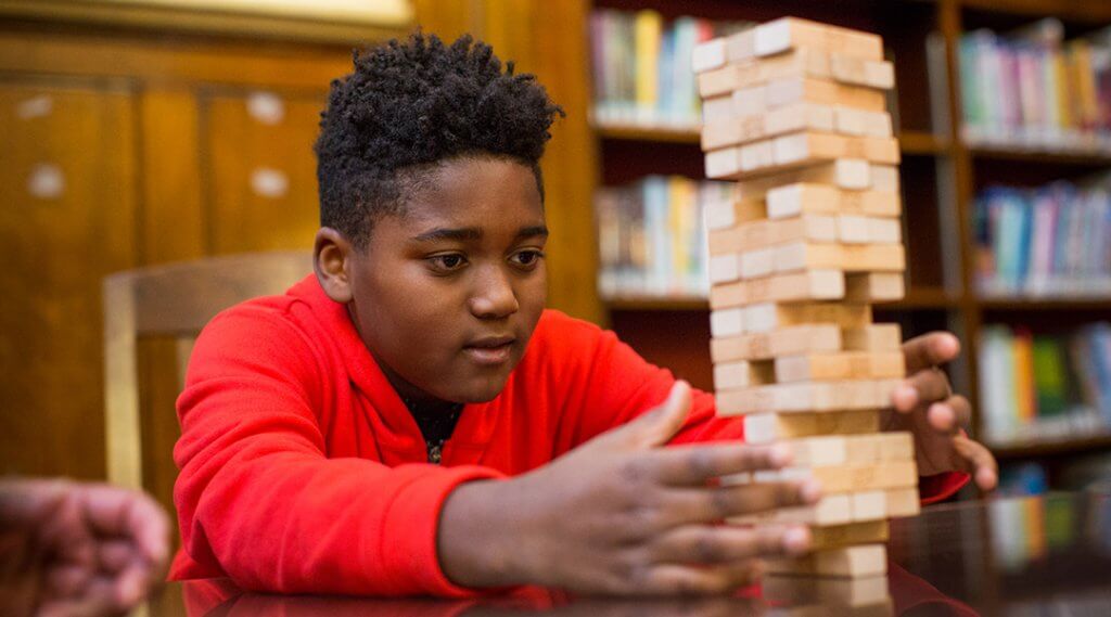 A child plays jenga in the library.