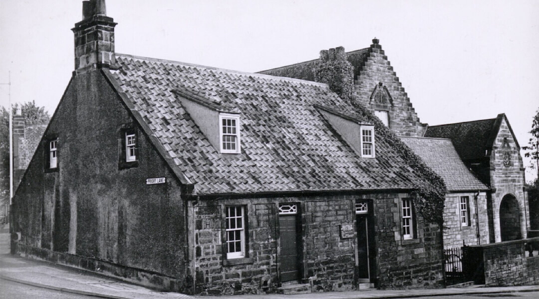 black and white photo of an old stone cottage