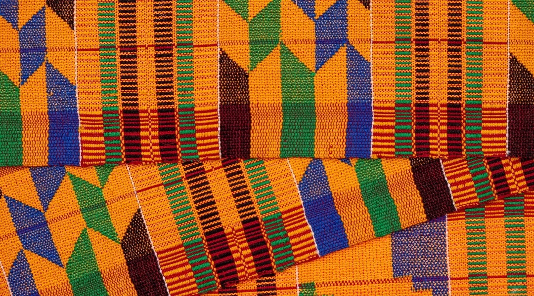 Close up of orange, blue and green Kente cloth