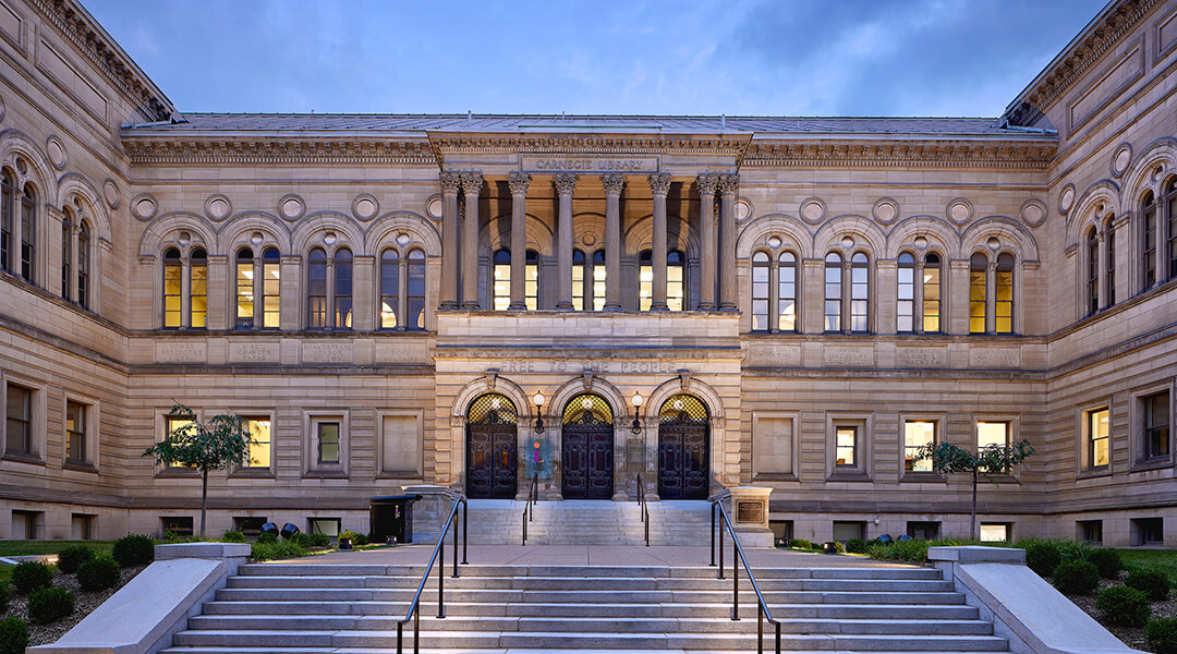 Exterior photograph of CLP - Main Library at night with warm, glowing windows