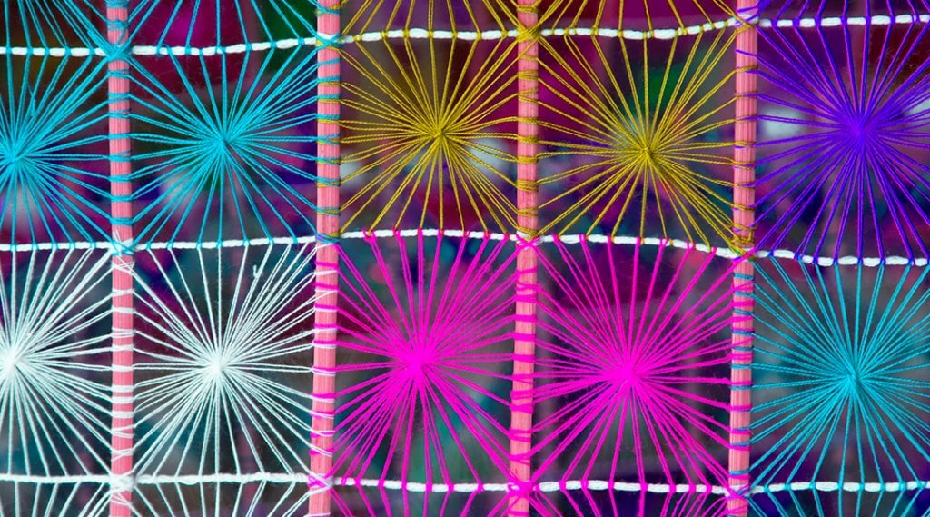 A web of different color string arranged in squares.