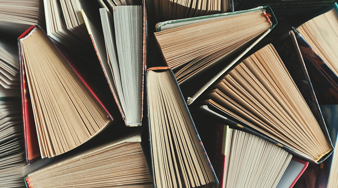 Overhead image of books propped open on a table.