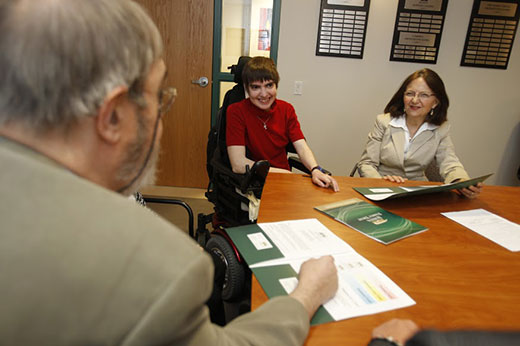 Person in wheelchair is at a meeting with two people.